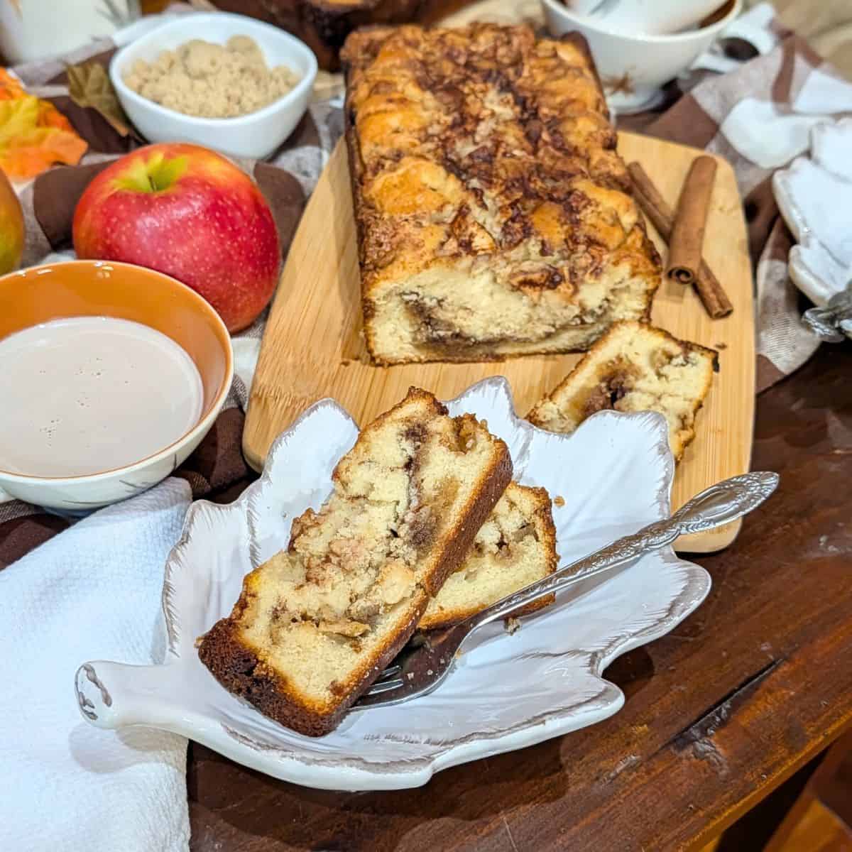Apple cinnamon bread loaf with brown sugar cinnamon topping on a wooden cutting board.