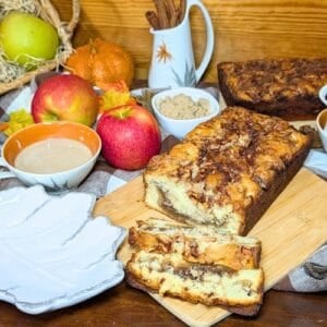 Cinnamon apple bread sliced and ready to serve on a wooden cutting board.