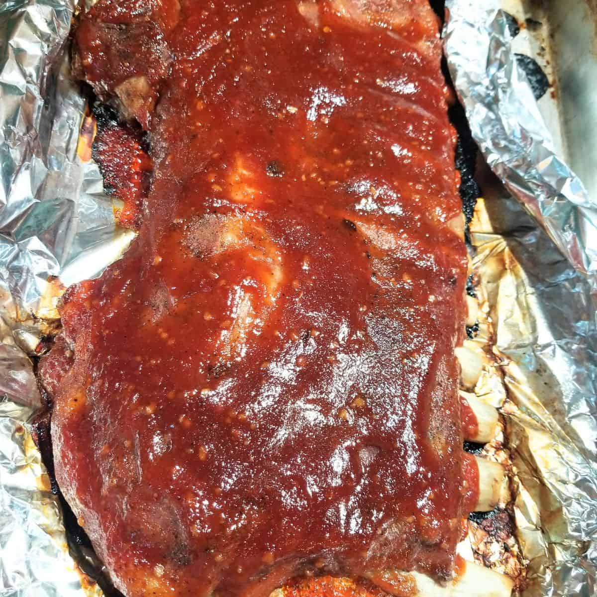 Tender fall-off-the-bone BBQ ribs fresh from the oven with caramelized barbecue sauce.