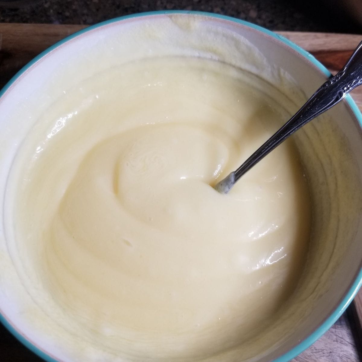 Mixed dressing in a bowl with a spoon.