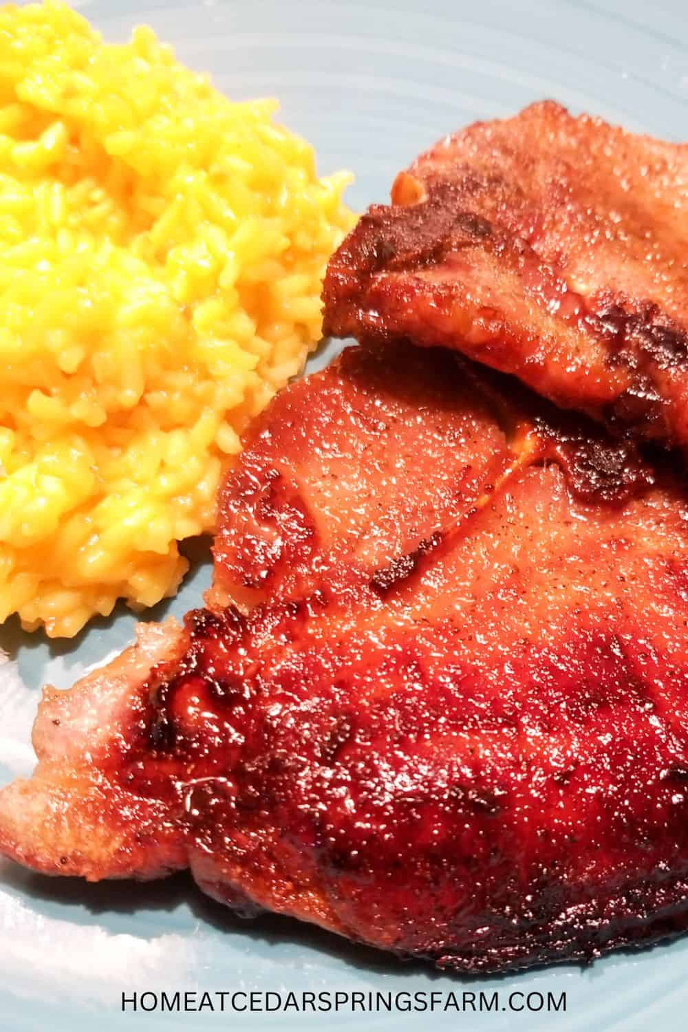 Oven Baked Bone-In Pork Chops on a blue plate with yellow rice.