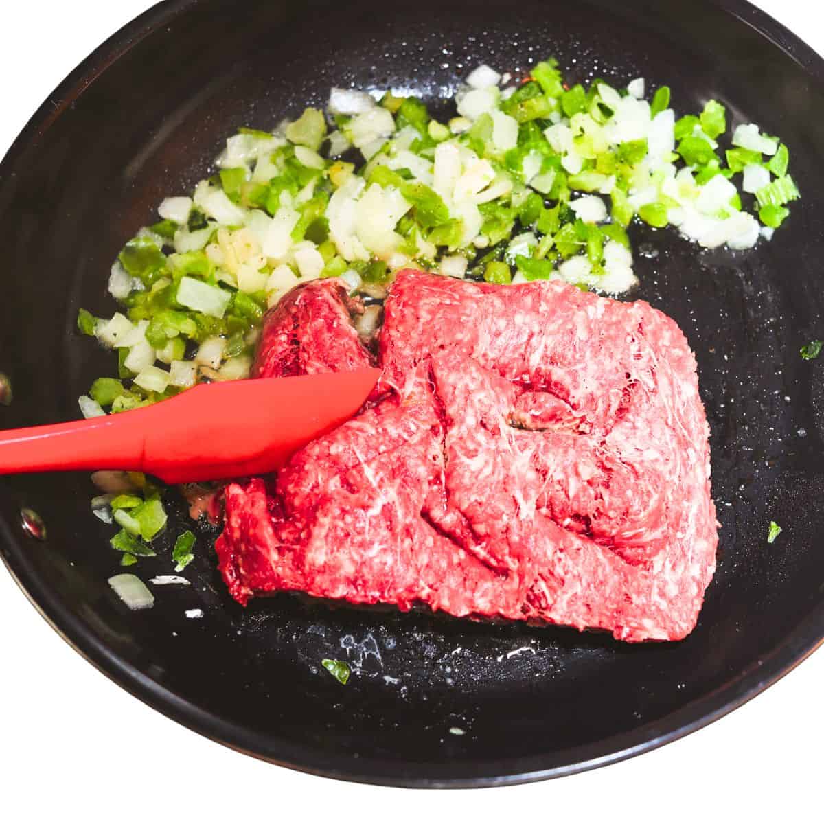 Cooking the meat and vegetables in a skillet.