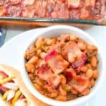 Baked beans with bacon in a bowl and baking dish.