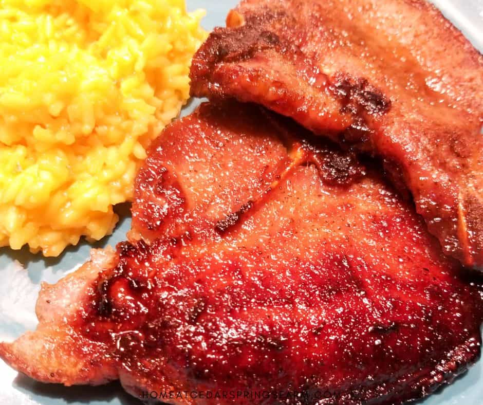 Oven Baked Bone-In Pork Chops on a blue plate with yellow rice.