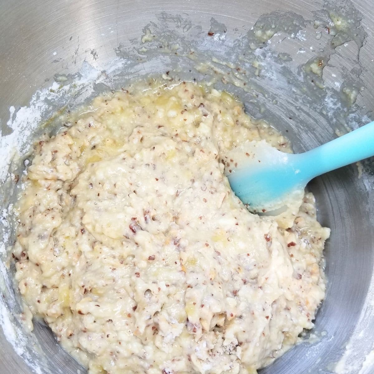 Folding the dry ingredients into the wet ingredients for the banana nut bread batter.
