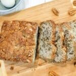 Banana Nut Bread on a wooden cutting board sliced and ready to serve.