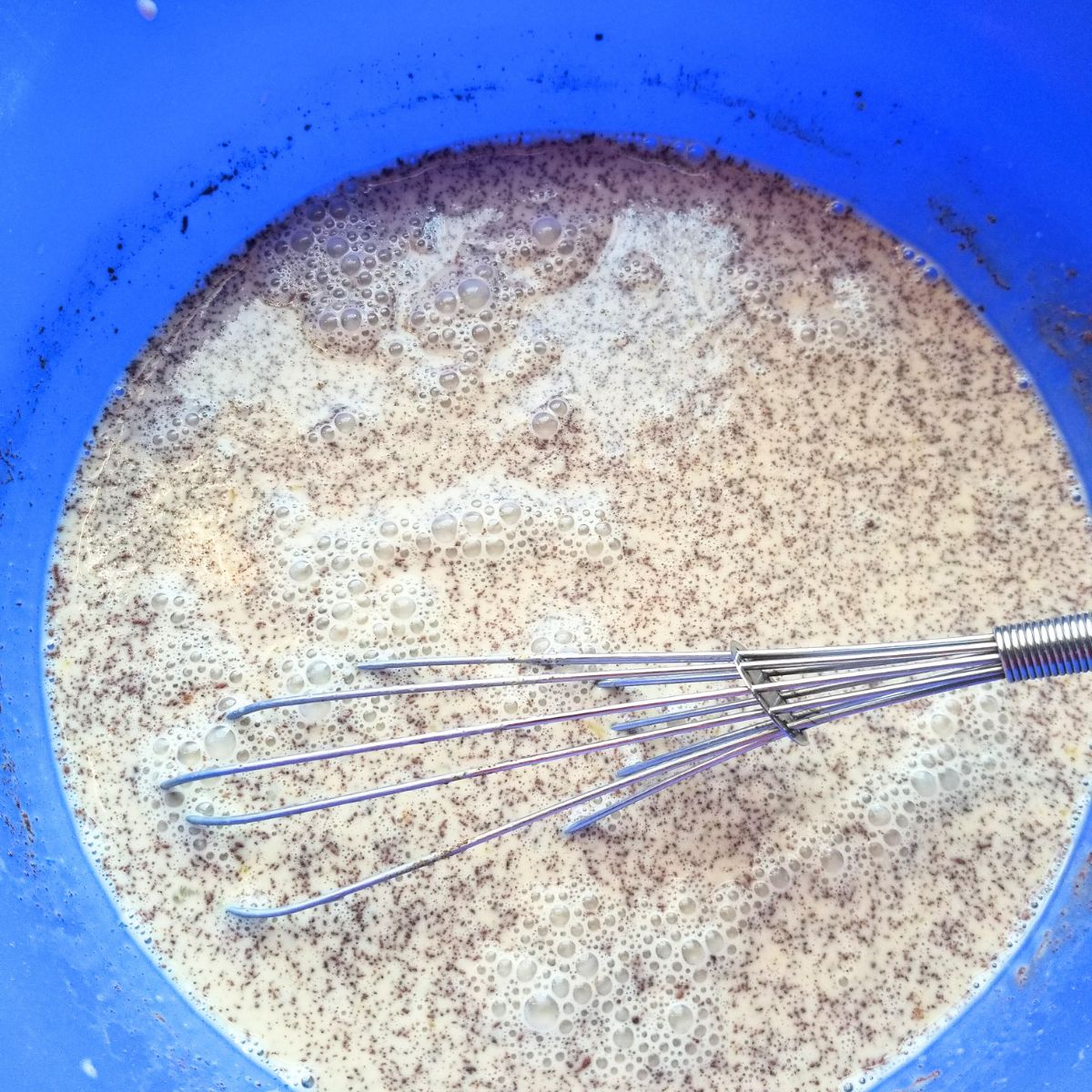 Flavorings added to the custard mixture in a blue mixing bowl.