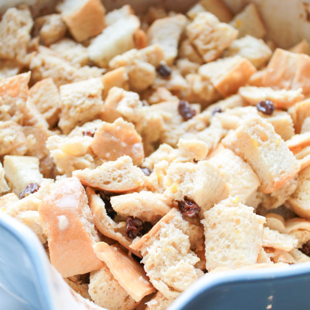 Custard mixture poured over cubed bread in a baking dish.