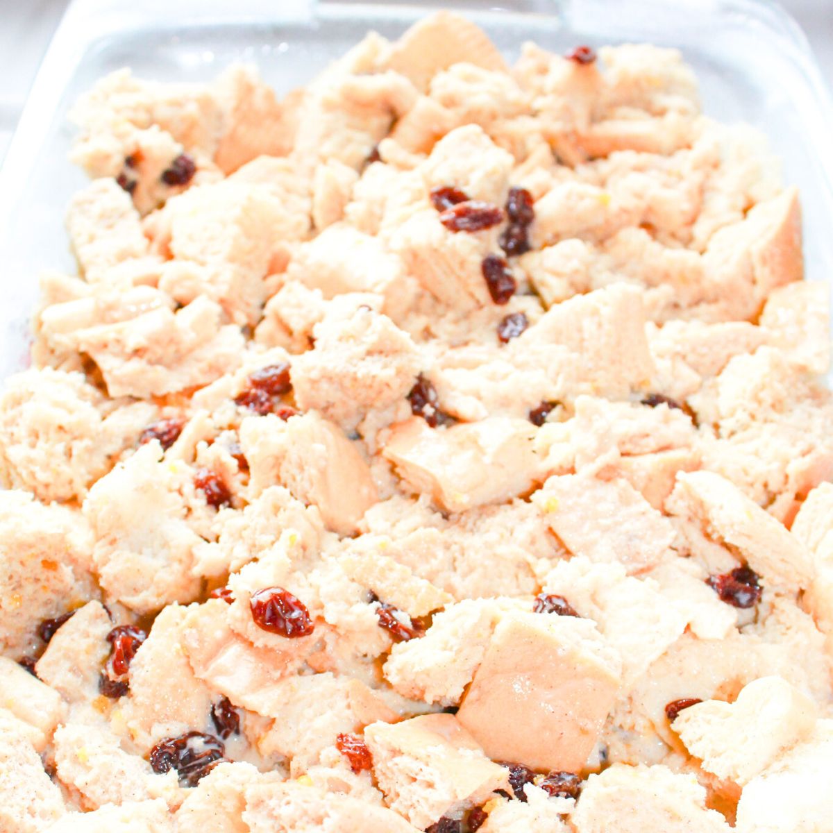 Bread pudding soaking in custard before baking.