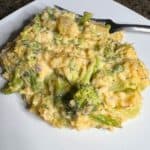 Broccoli and rice casserole on a white plate with a fork.