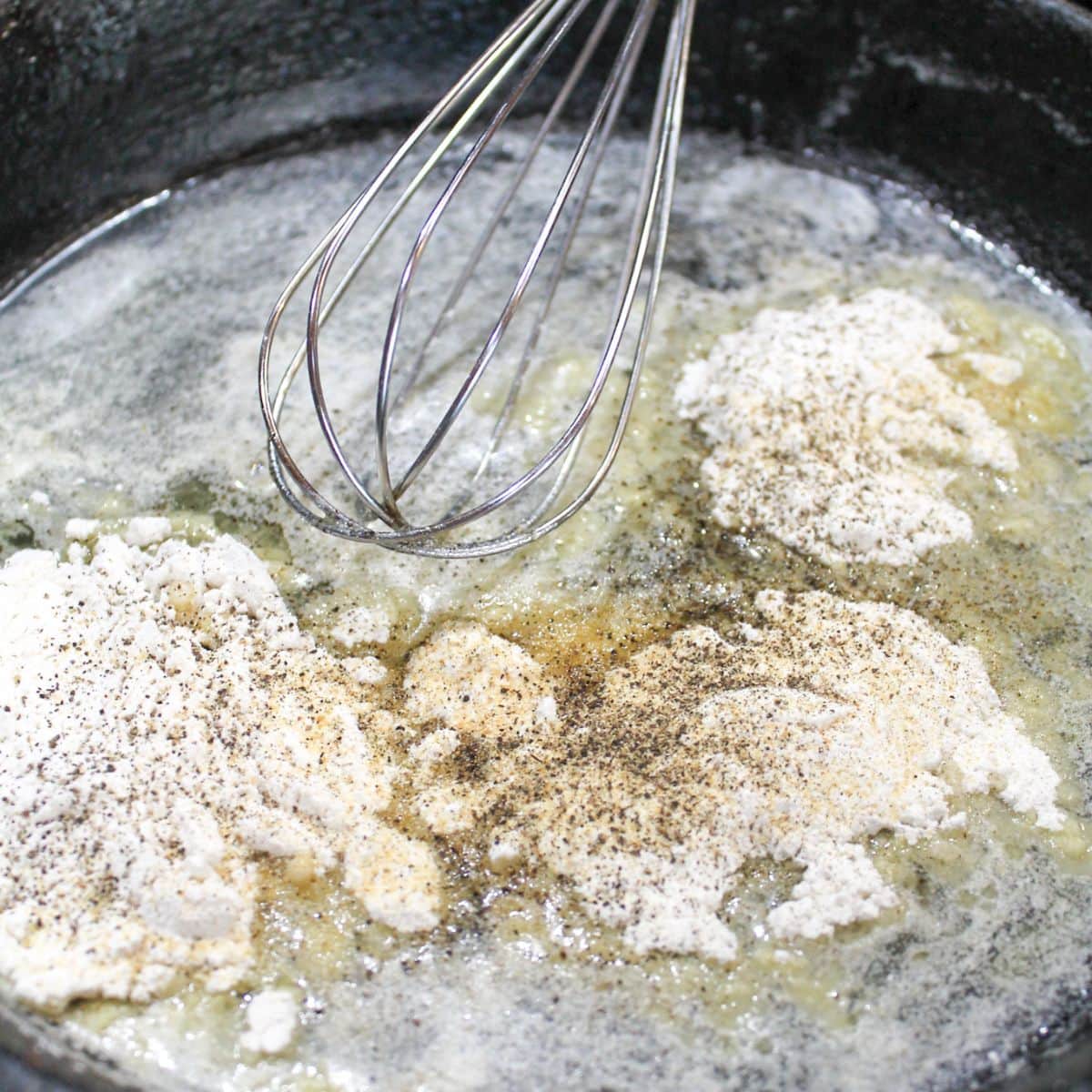 Flour and seasonings added to the cast iron skillet.