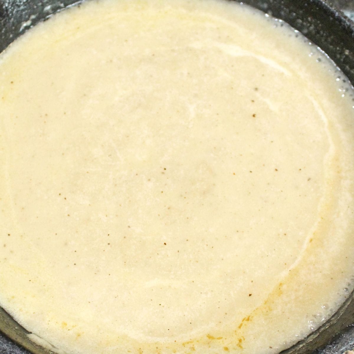 Cooked brown gravy in a cast iron skillet.