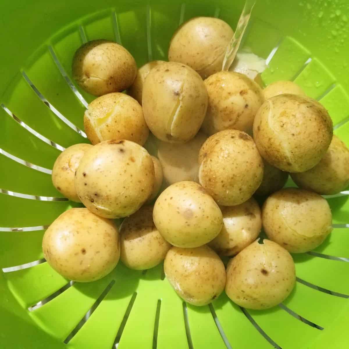 Draining cooked potatoes in colander after boiling.