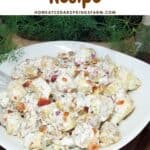 Potato salad in a bowl sitting on a farmhouse table with text overlay.