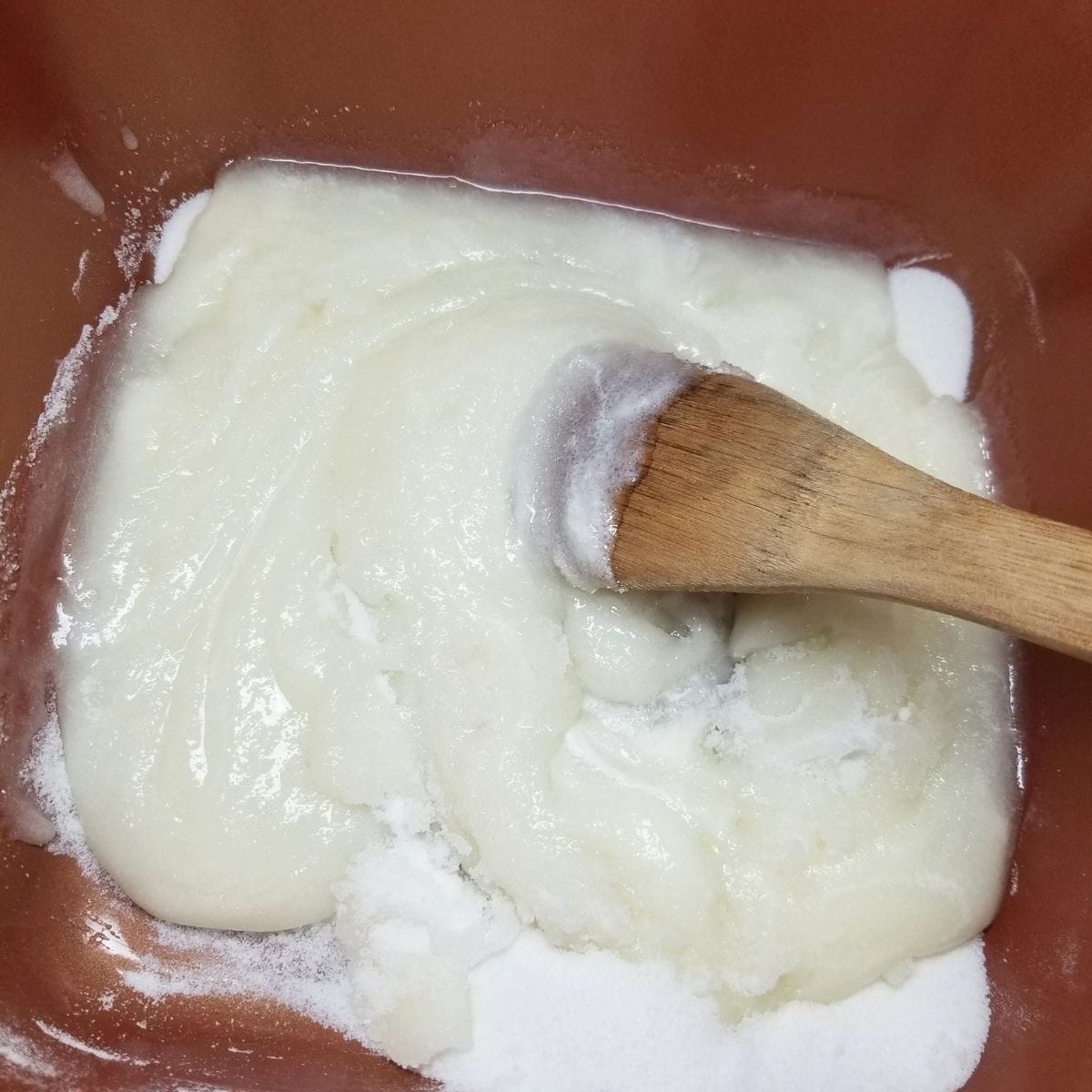 Ingredients in a saucepan with a wooden spoon.