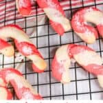 Candy cane cookies on a baking rack with text overlay.