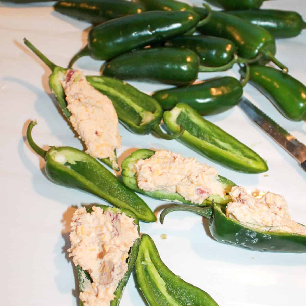 Whole and sliced jalapenos with a cheese filling in a few.