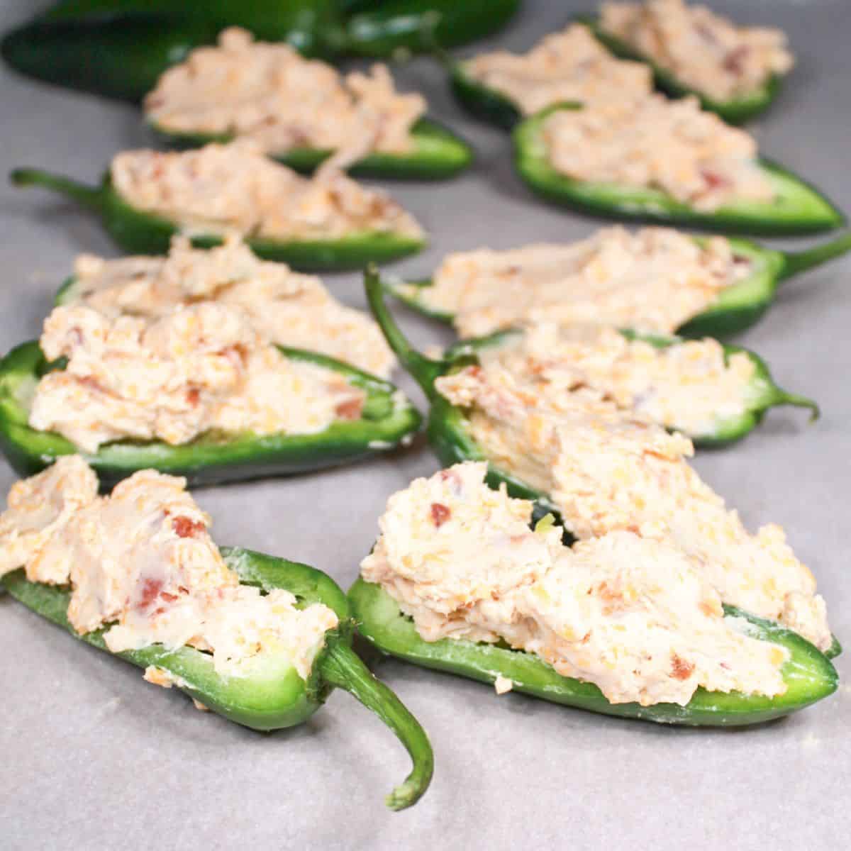 Stuffed jalapenos on a baking sheet.