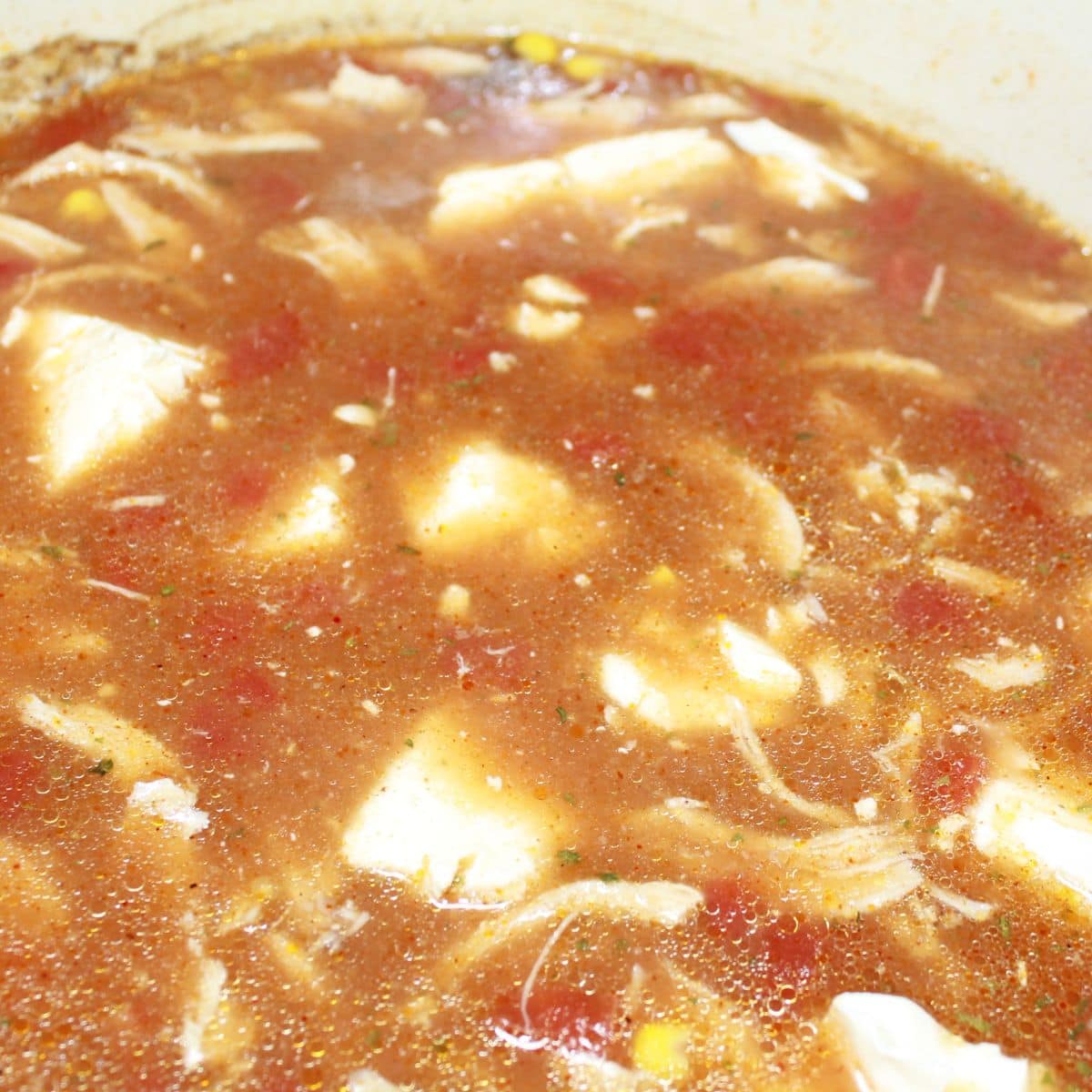 Adding cream cheese to the soup base.