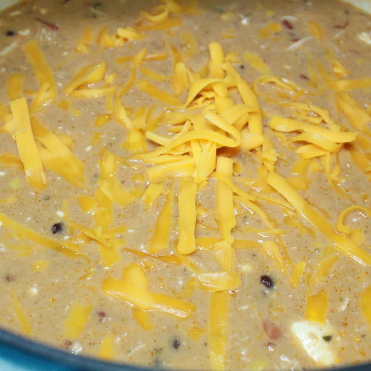 Adding cheese to the soup.