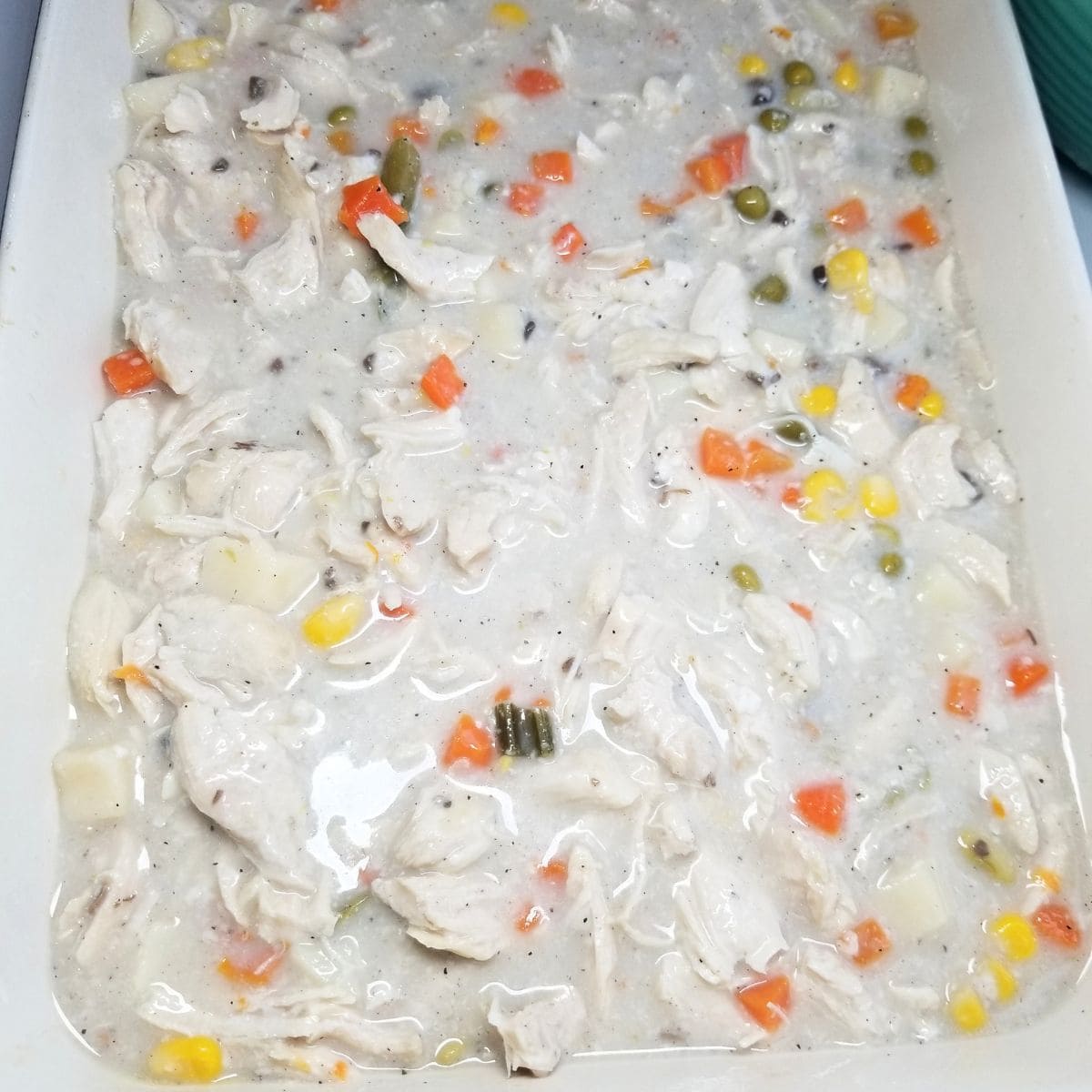 Pouring the chicken filling in a baking dish.