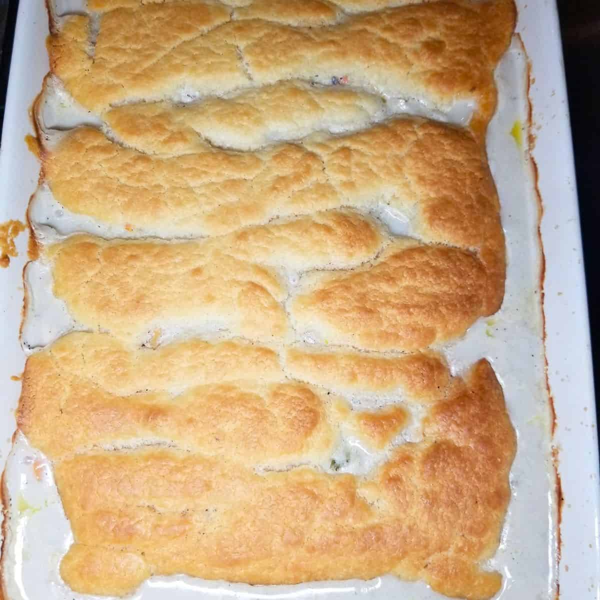 Easy chicken pot pie casserole with golden crust served from 9x13 dish.
