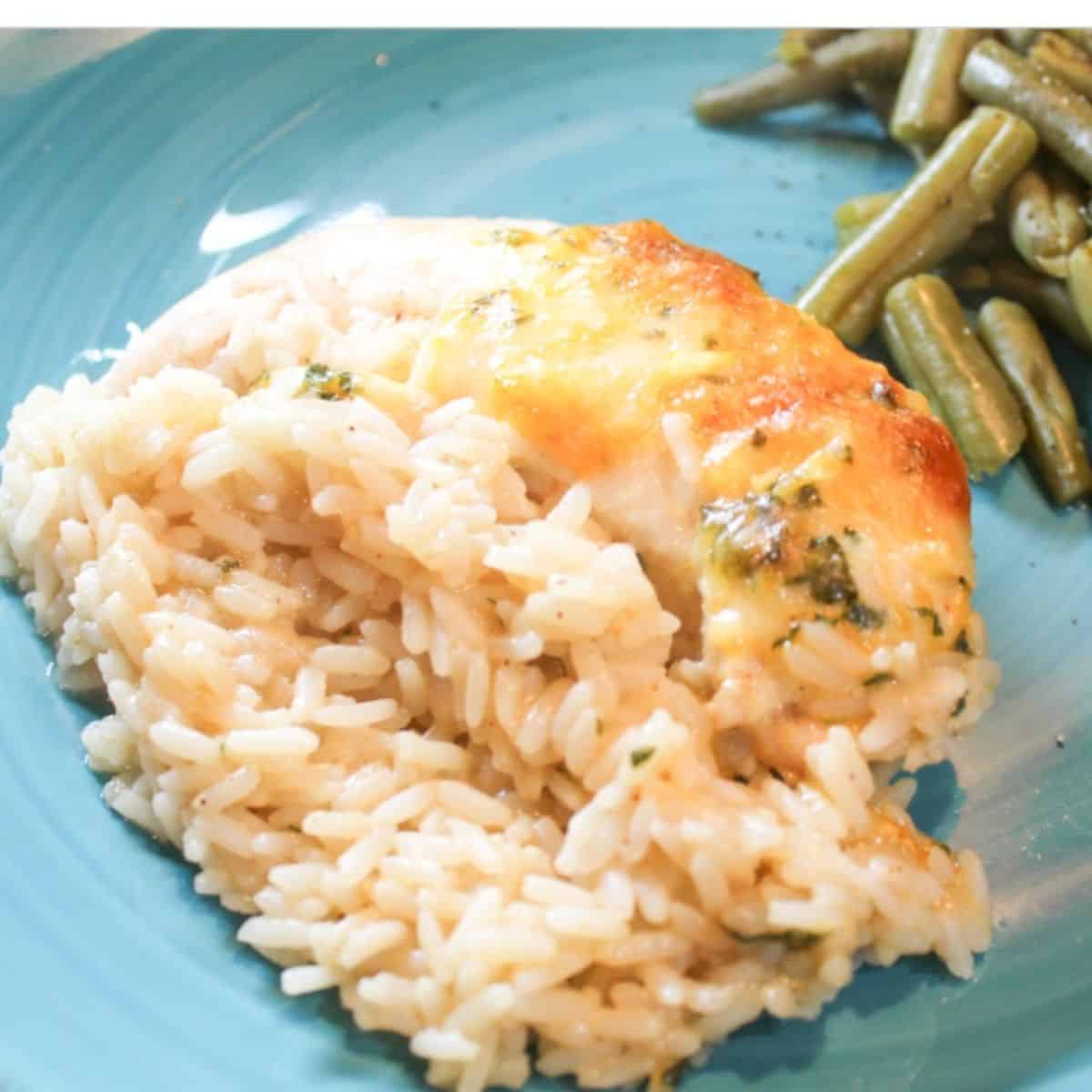Chicken, rice, and green beans on a a blue plate.