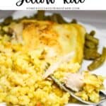Chicken and rice on a white plate with a fork and green beans.
