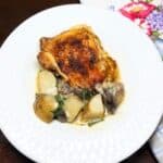 Baked chicken and potatoes in a serving bowl.