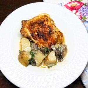 Baked chicken and potatoes in a serving bowl.