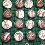 Chocolate Covered Ritz Crackers on a baking rack with a green towel under the rack.