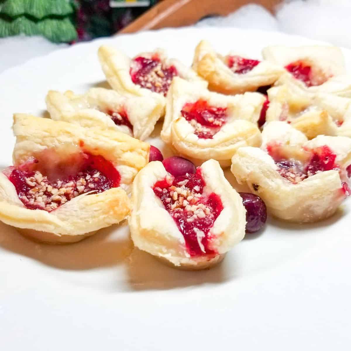 Cranberry brie bites on a white serving platter.