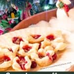 Cranberry Brie Bites on a white serving platter with Christmas decor in the picture.