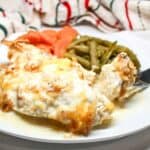 Chicken, green beans, and carrots on a white plate.
