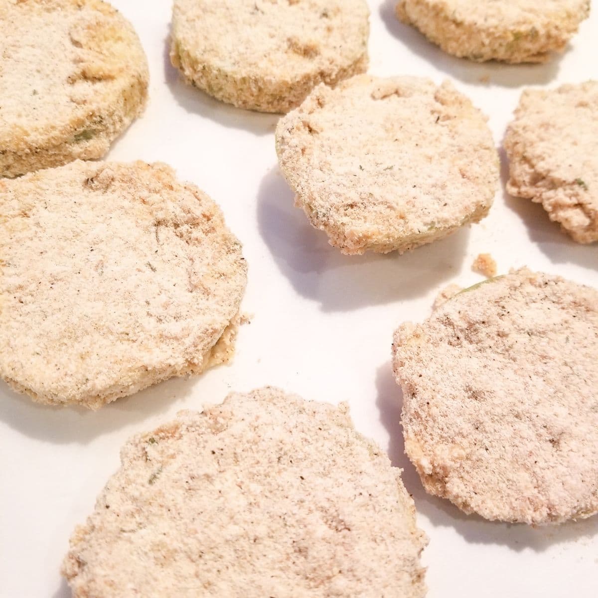 Breaded tomatoes on parchment paper.