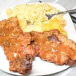 Fried Cubed Steak and rice casserole on a white plate with a fork.