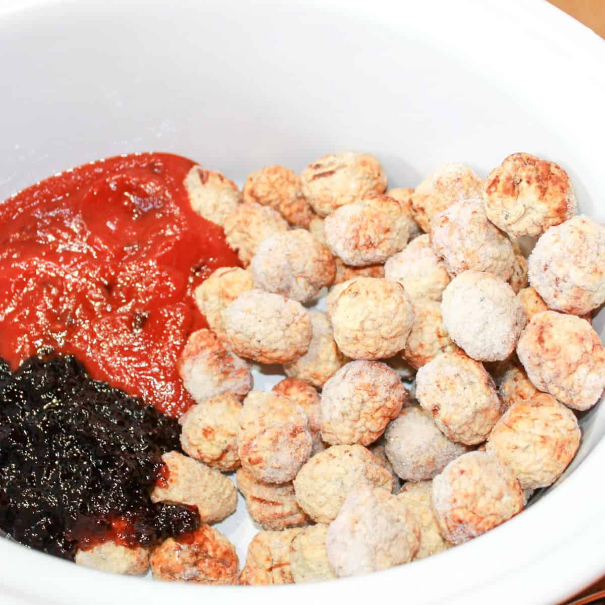 Meatballs, chili sauce and grape jelly in a slow cooker.