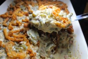 Green bean casserole in a baking dish with a spoon.
