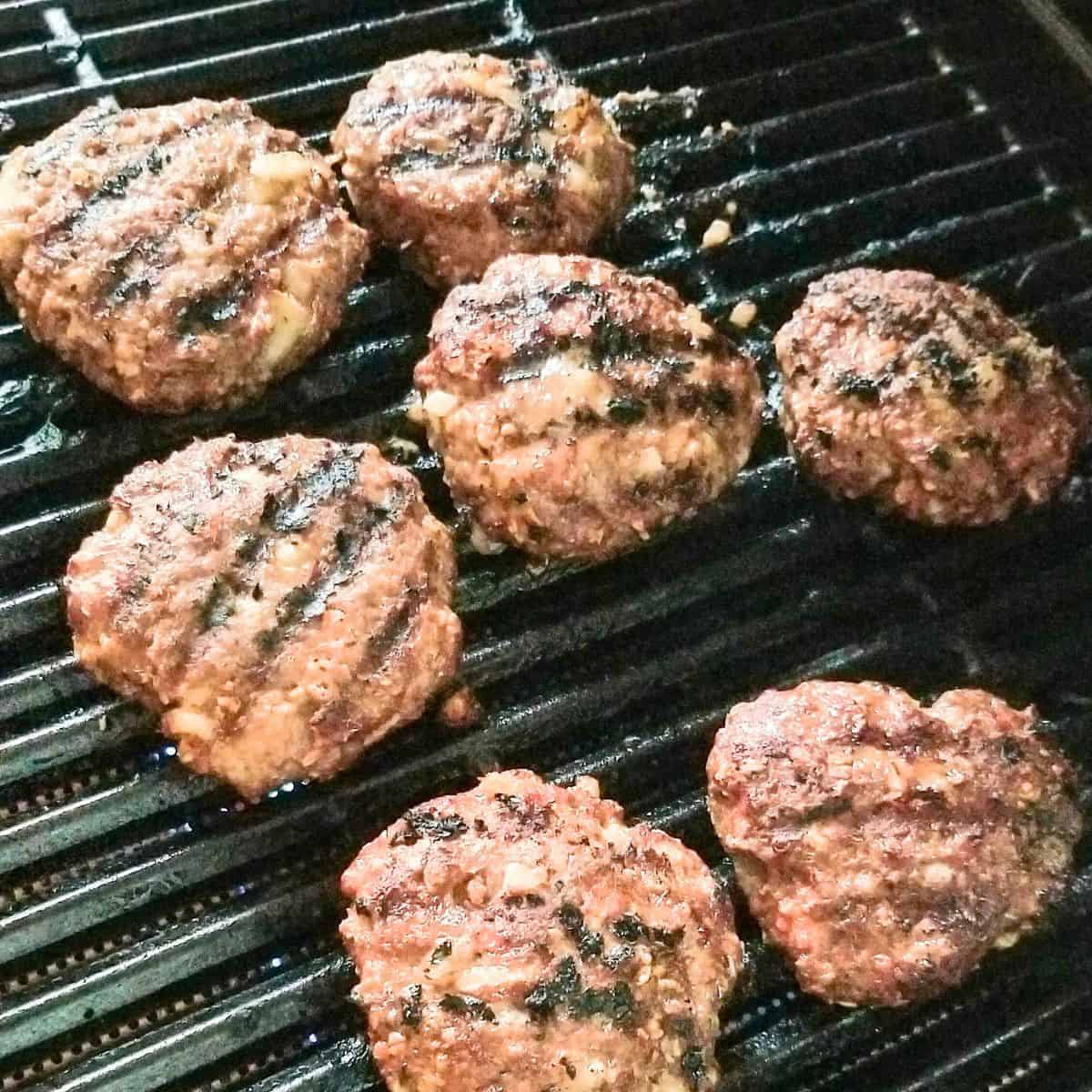 Grilling hamburger patties on a gas grill.