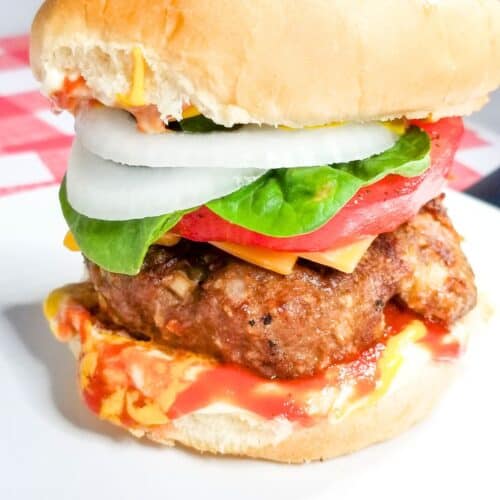 Grilled hamburger on a bun with burger toppings.