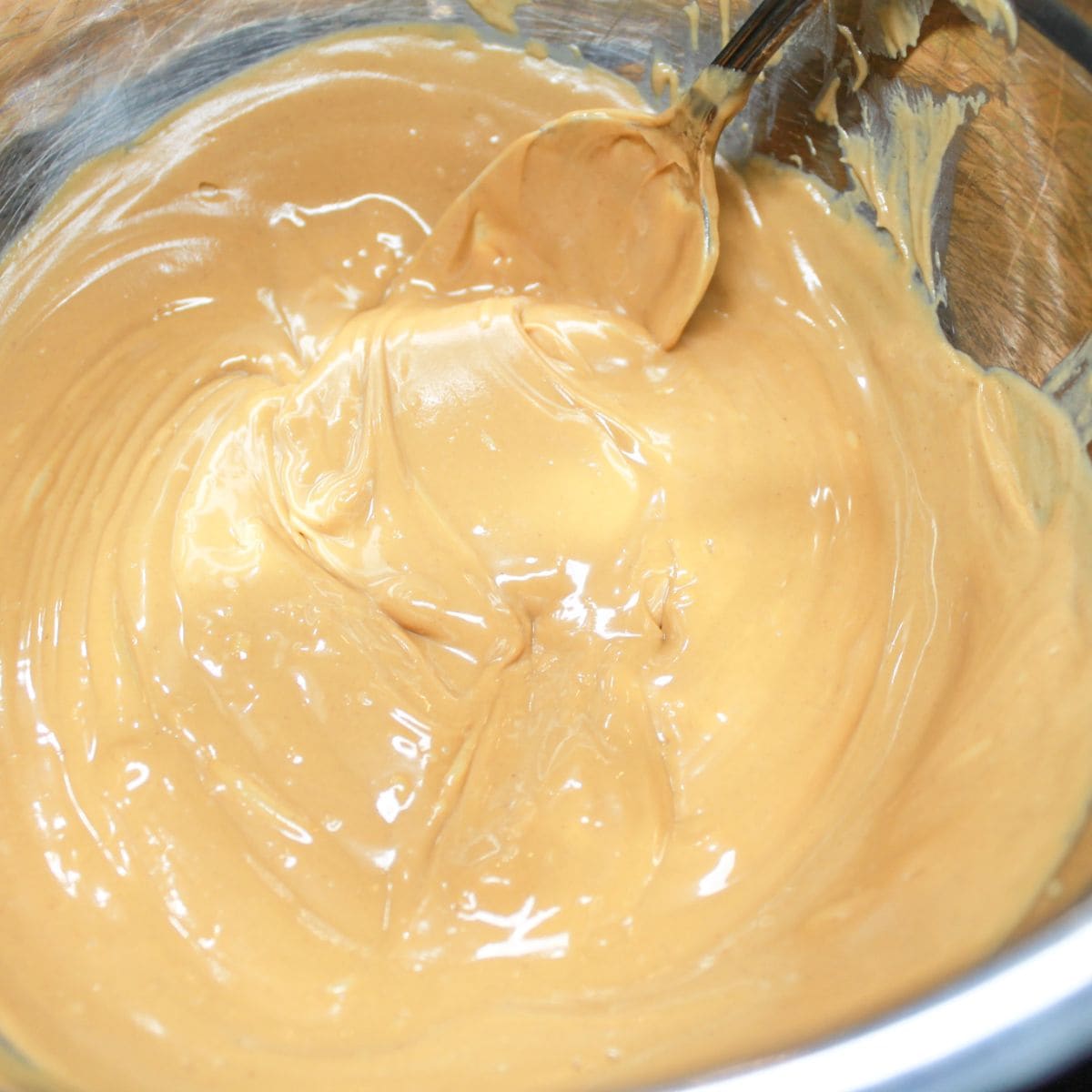 Melted butterscotch chips in a pan with a spoon.