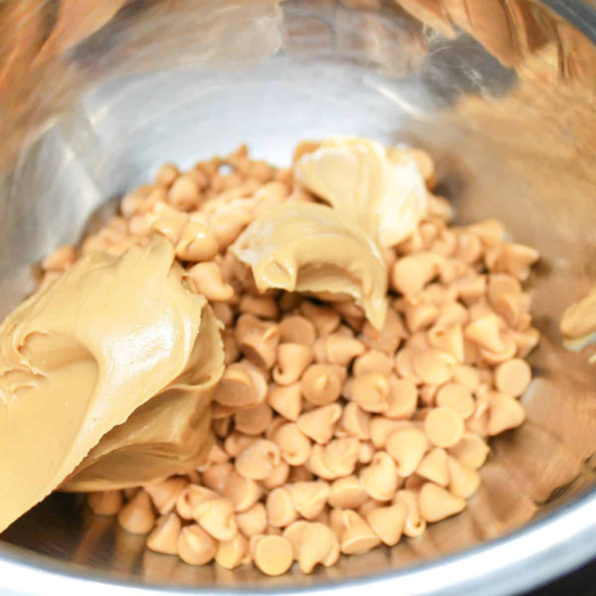 Peanut butter and butterscotch chips in a bowl with a spoon.
