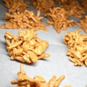 Peanut butter haystacks on white parchment paper.