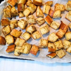 Croutons on a parchment paper lined baking sheet.