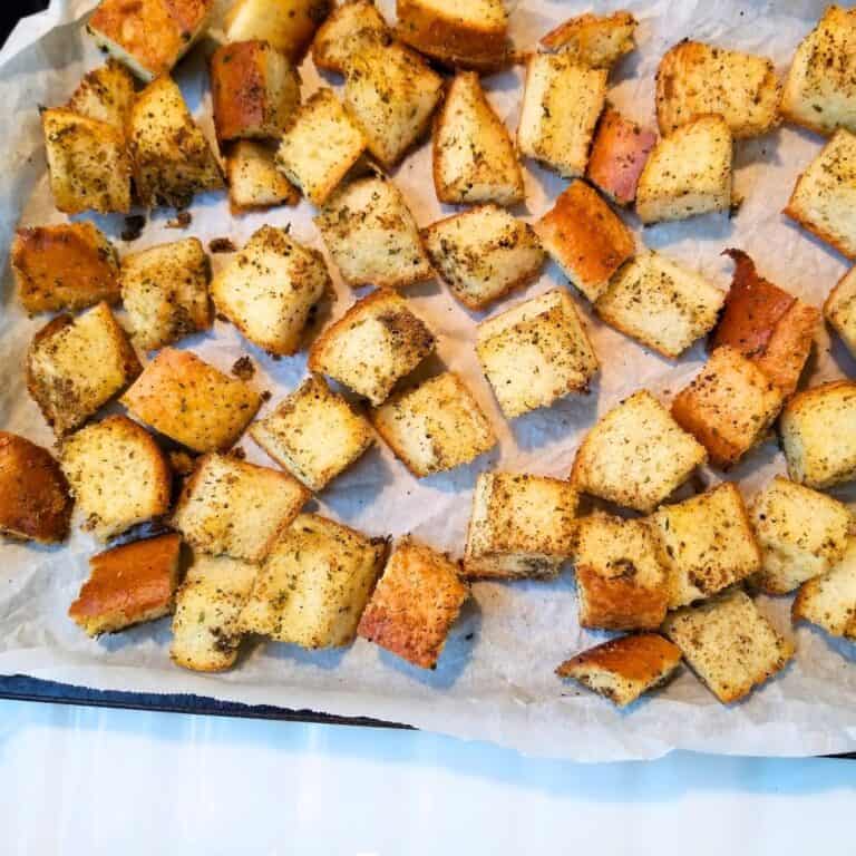Croutons on a parchment paper lined baking sheet.
