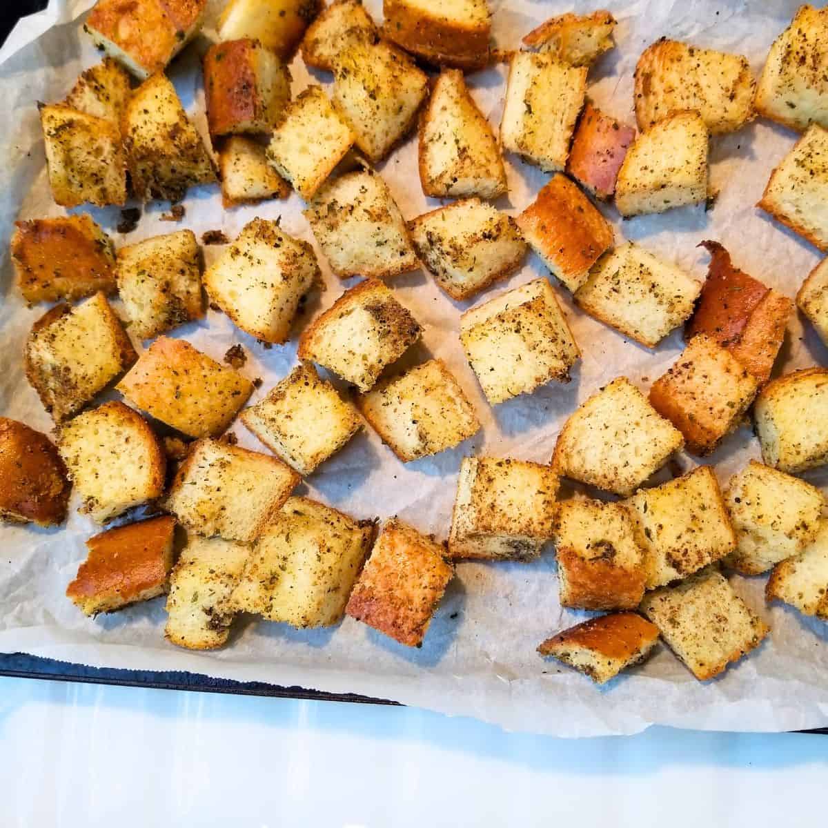 Croutons on a parchment paper lined baking sheet.