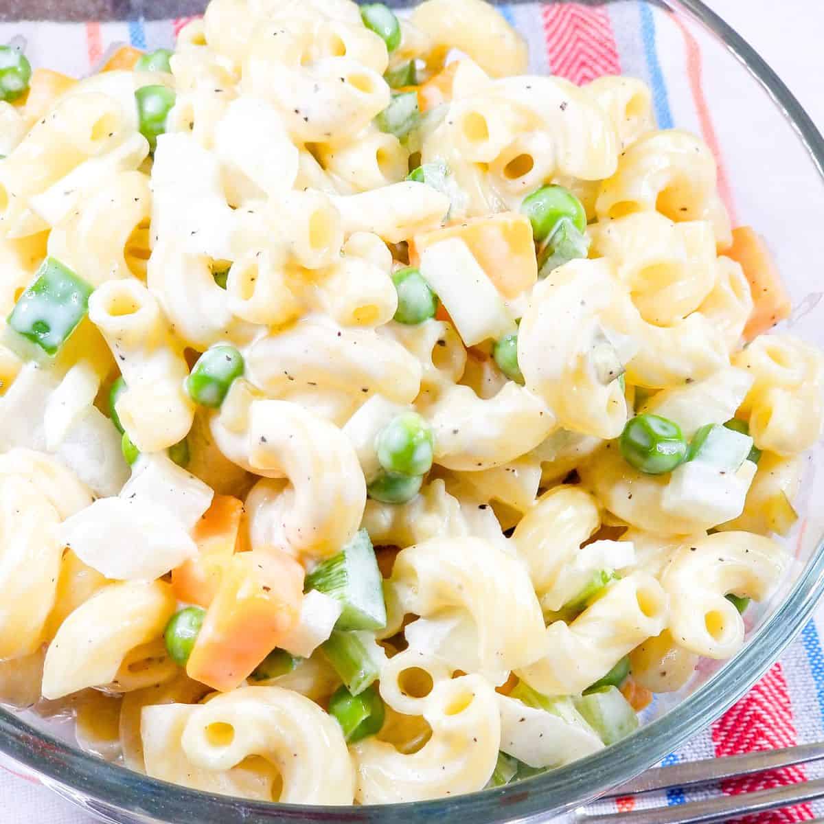 Old fashioned Southern macaroni salad with peas and cheese in a serving bowl.