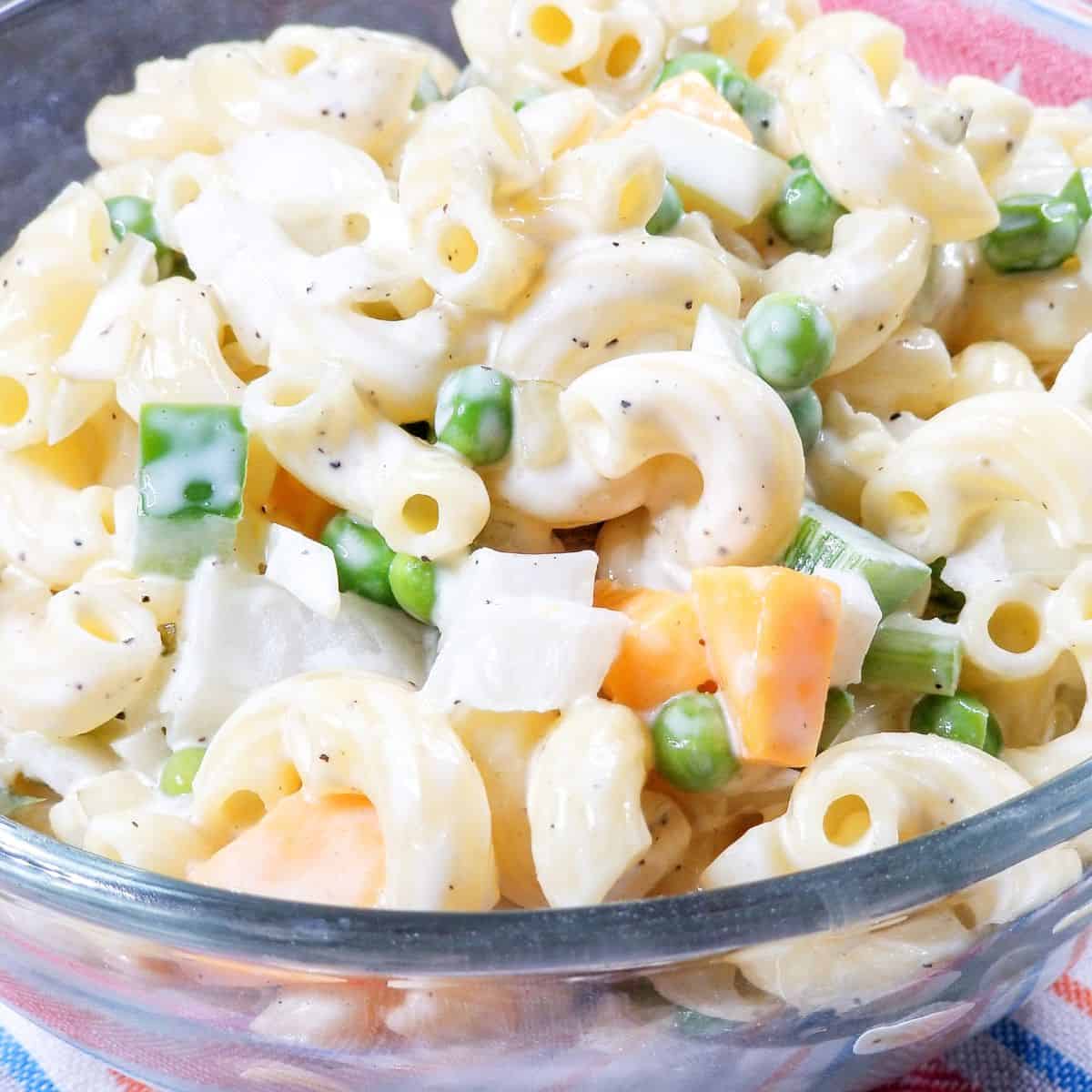 Old fashioned Southern macaroni salad with peas and cheese in a serving bowl.
