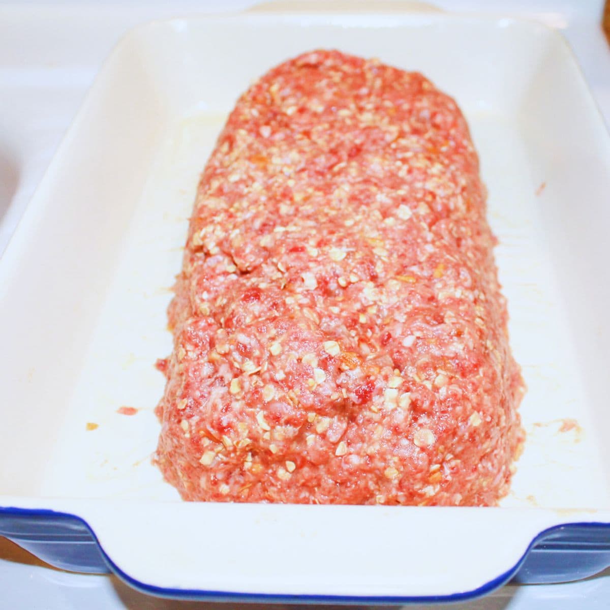 Meatloaf shaped in a baking dish ready for the oven.