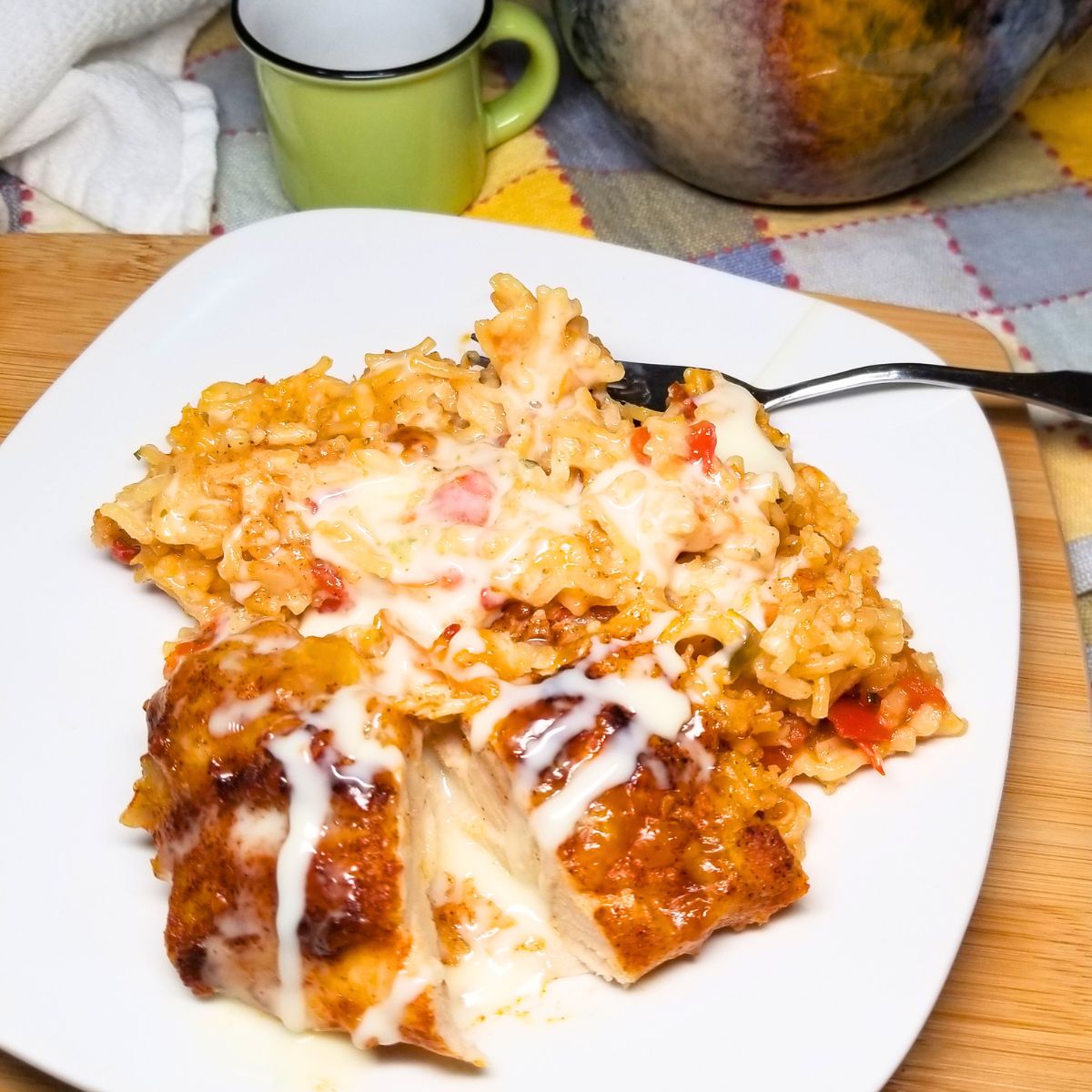 Easy weeknight chicken casserole recipe with queso drizzle on a white plate sitting on a farmhouse table.